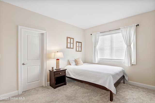 bedroom featuring baseboards and light colored carpet