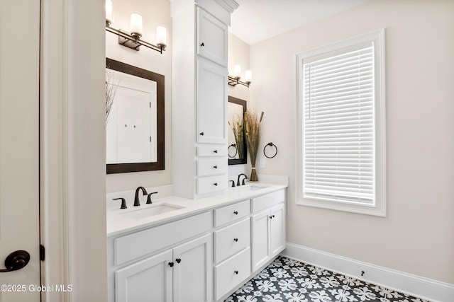 bathroom featuring double vanity, baseboards, and a sink