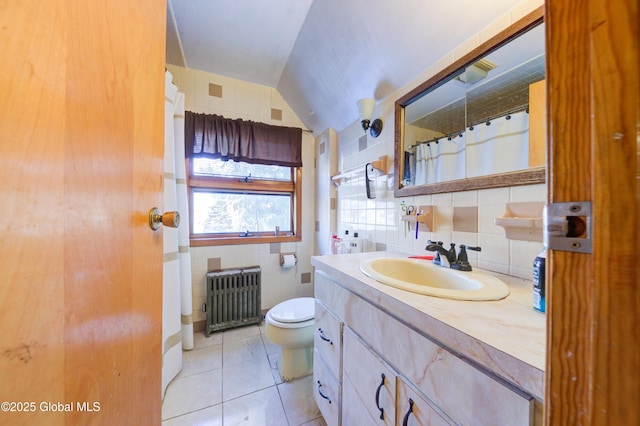 bathroom with tile patterned floors, toilet, tile walls, radiator heating unit, and vanity