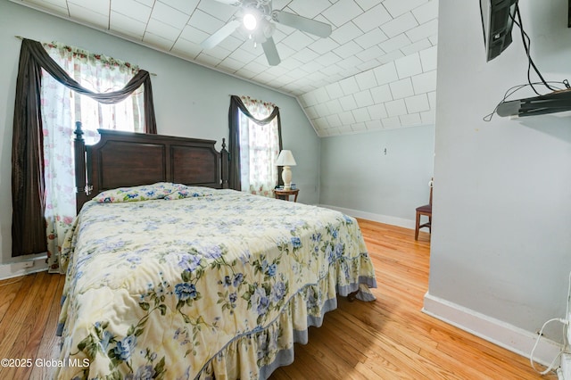 bedroom with wood-type flooring, ceiling fan, and vaulted ceiling