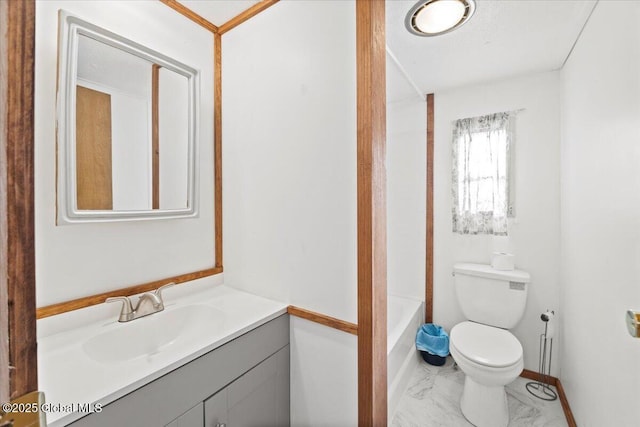 bathroom with vanity, a bathtub, and toilet