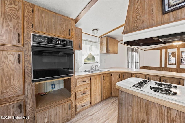 kitchen with sink, white gas cooktop, light hardwood / wood-style flooring, black oven, and custom range hood