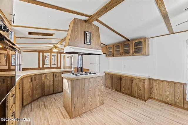 kitchen with a center island, vaulted ceiling with beams, light hardwood / wood-style floors, and white gas cooktop