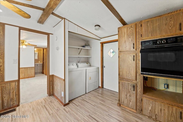 laundry room featuring washer / clothes dryer, wooden walls, a textured ceiling, and light wood-type flooring