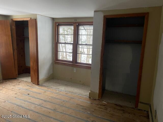 unfurnished bedroom with light wood-type flooring and a closet