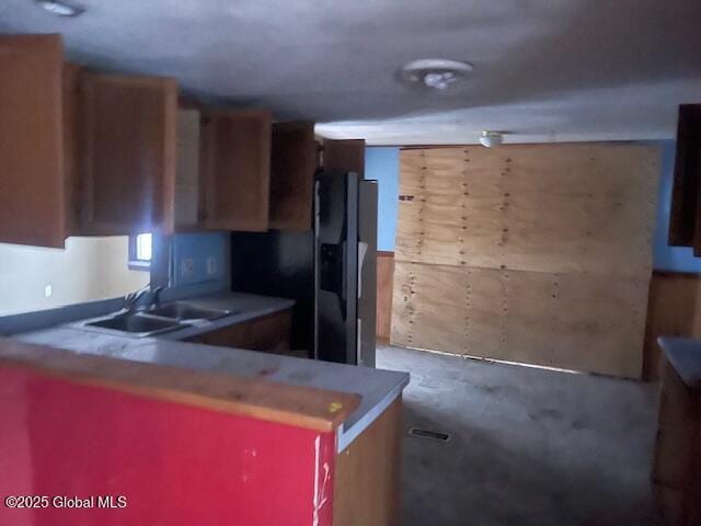 kitchen featuring sink, fridge with ice dispenser, and kitchen peninsula