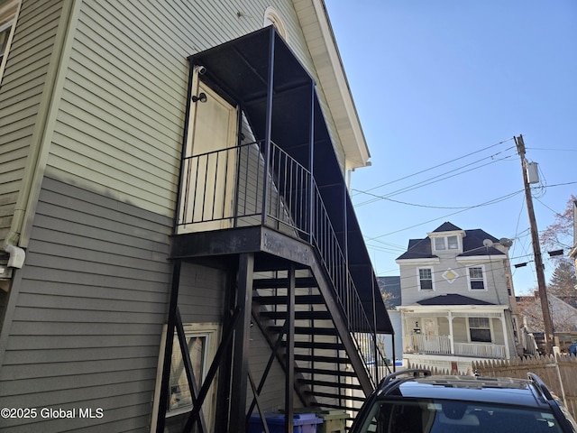 view of property exterior with stairs and fence