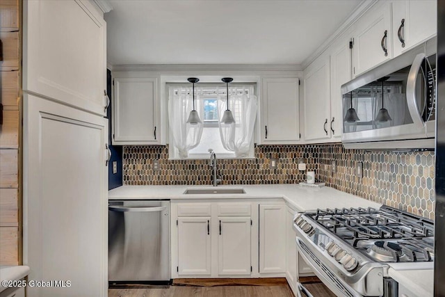 kitchen featuring sink, white cabinetry, decorative light fixtures, stainless steel appliances, and backsplash