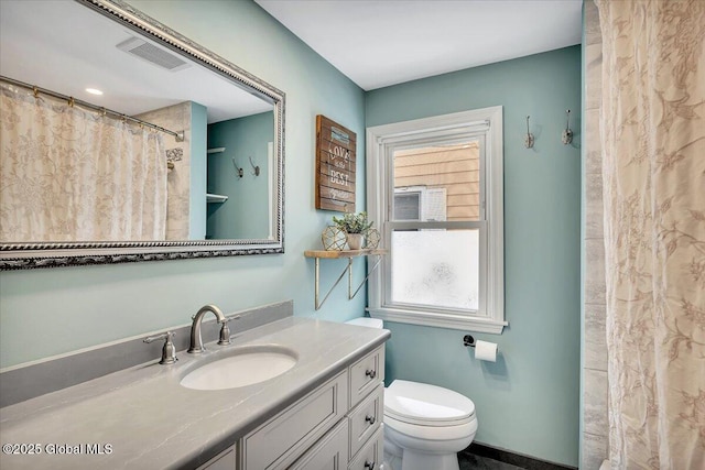 bathroom featuring vanity, toilet, and walk in shower