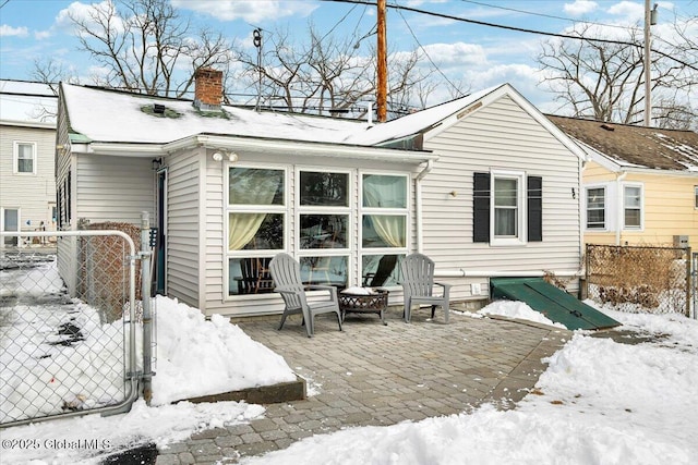 snow covered property featuring a fire pit and a patio