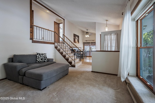 carpeted living area with stairs, ceiling fan, baseboards, and a healthy amount of sunlight