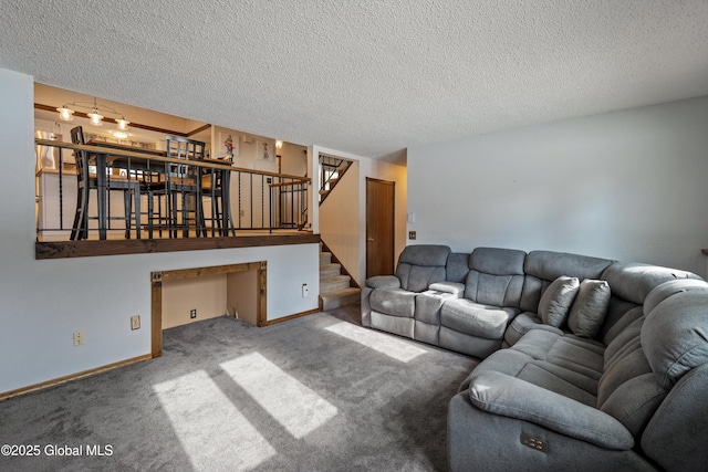 carpeted living area with baseboards, stairway, and a textured ceiling