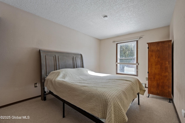 bedroom featuring light carpet, a textured ceiling, and baseboards