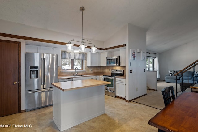 kitchen featuring white cabinetry, wood counters, appliances with stainless steel finishes, and a sink