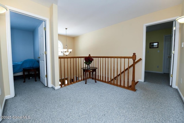 hallway with carpet and an inviting chandelier