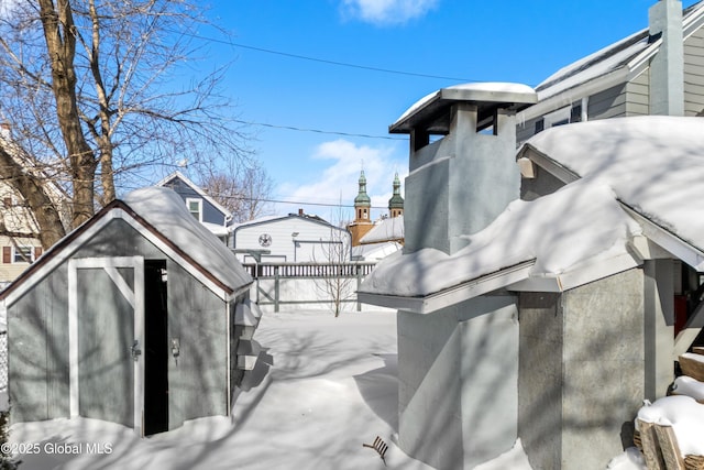 exterior space with a storage shed, stucco siding, and an outbuilding