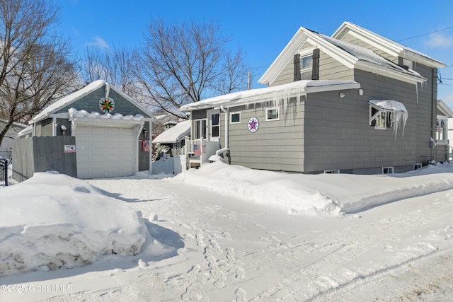 view of front of house with a detached garage and fence