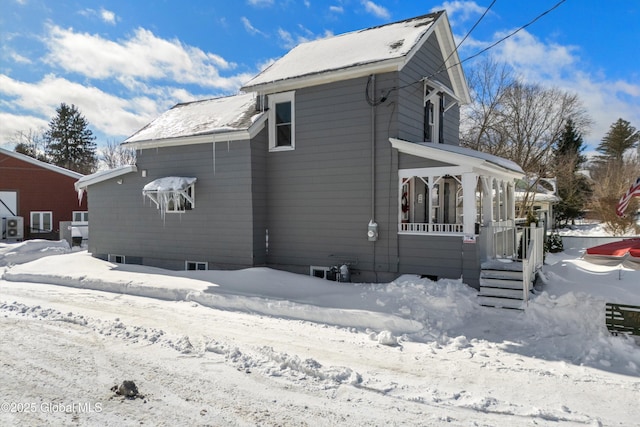 view of snow covered exterior with a porch