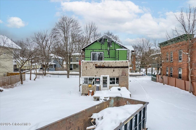 view of snow covered back of property