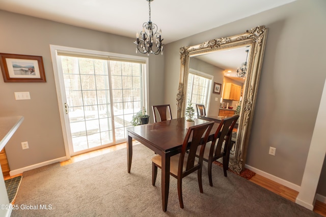 dining space featuring hardwood / wood-style floors and an inviting chandelier