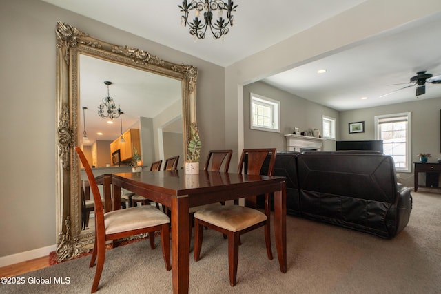 dining space featuring ceiling fan with notable chandelier