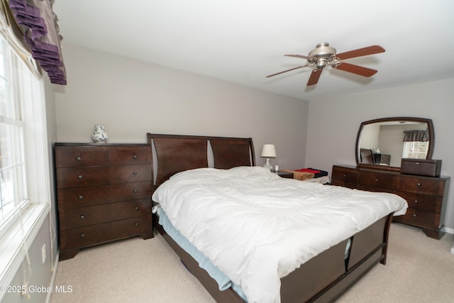 bedroom with multiple windows, light carpet, and ceiling fan