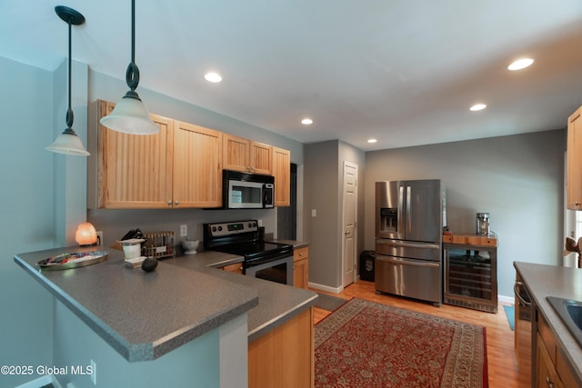 kitchen featuring appliances with stainless steel finishes, pendant lighting, light brown cabinetry, beverage cooler, and kitchen peninsula