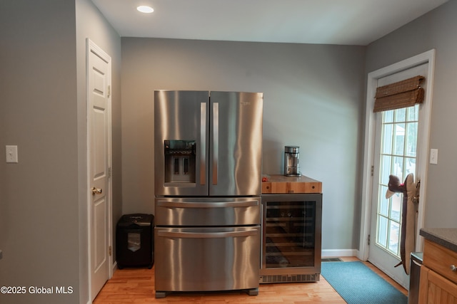 kitchen featuring wine cooler, stainless steel fridge, and light wood-type flooring