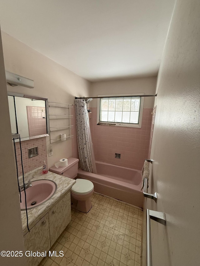 full bathroom with vanity, decorative backsplash, toilet, and shower / bath combo with shower curtain