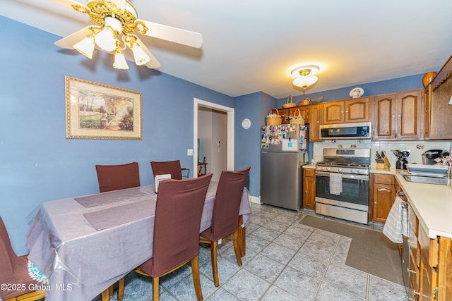 kitchen with appliances with stainless steel finishes, sink, backsplash, and ceiling fan