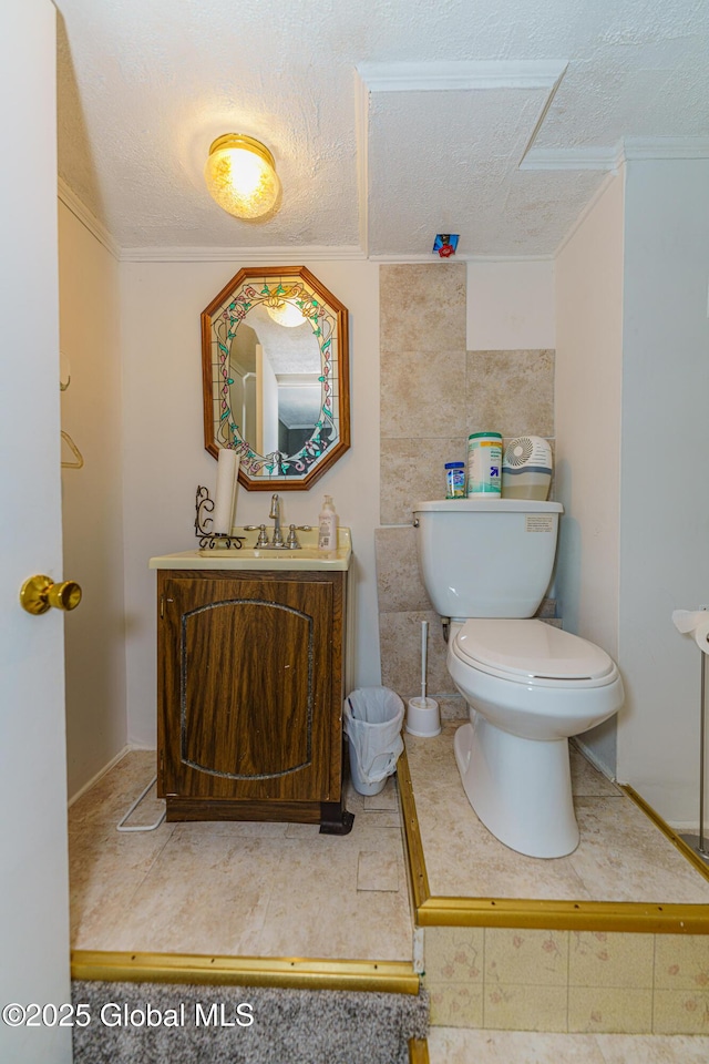 bathroom featuring toilet, crown molding, a textured ceiling, vanity, and tile patterned flooring