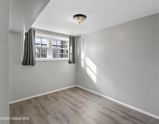 unfurnished room featuring wood finished floors and baseboards