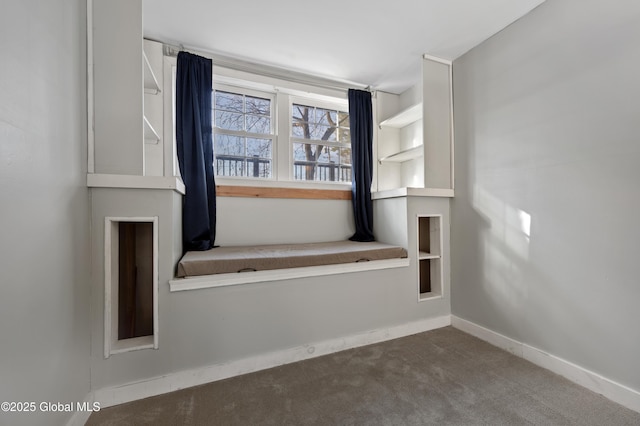 carpeted empty room featuring baseboards