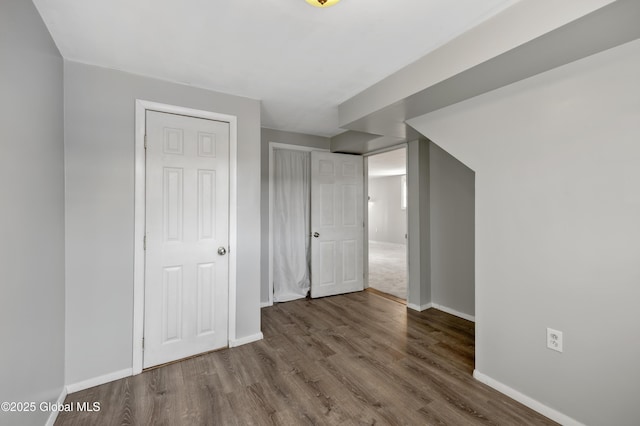 interior space with wood finished floors, baseboards, and a closet