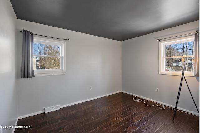 unfurnished room with visible vents, baseboards, and wood-type flooring