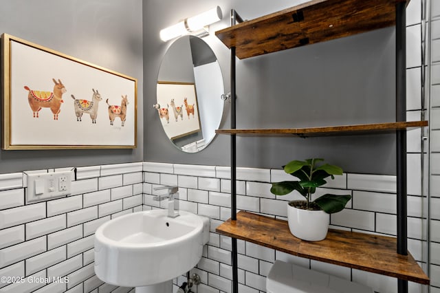 bathroom featuring a sink, tile walls, and wainscoting