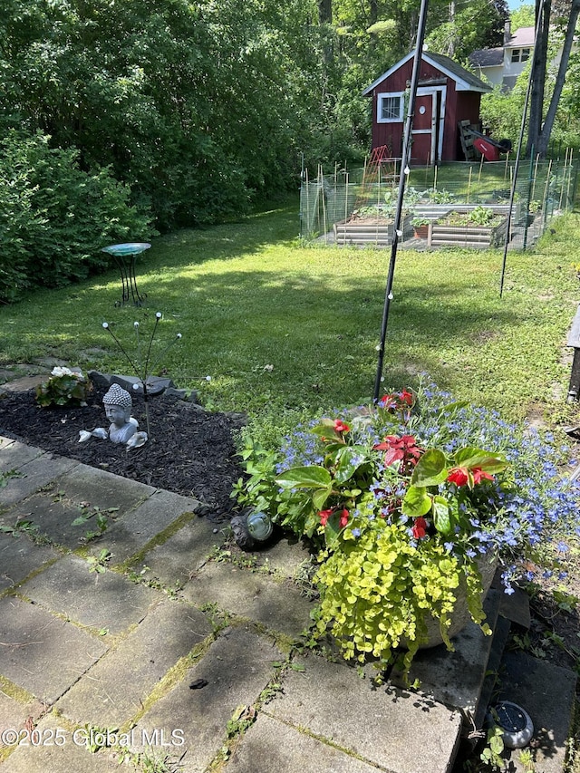 view of yard with a storage unit, an outdoor structure, and a garden