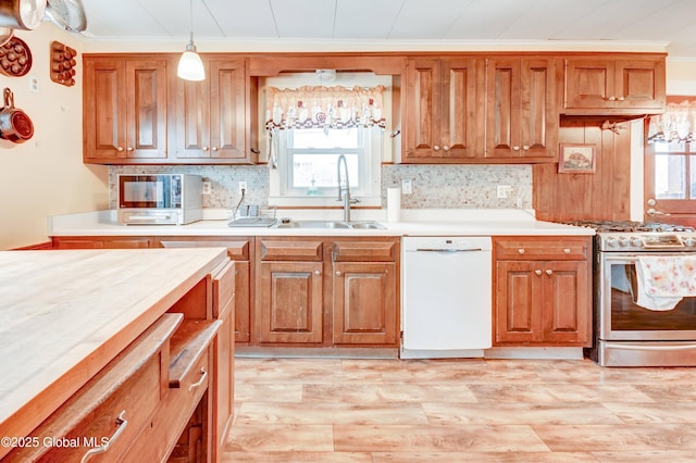 kitchen featuring dishwasher, light countertops, tasteful backsplash, and stainless steel gas stove