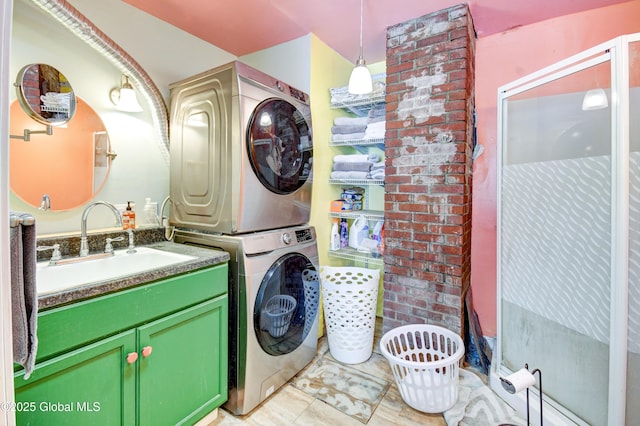 washroom featuring a sink, laundry area, and stacked washer / drying machine