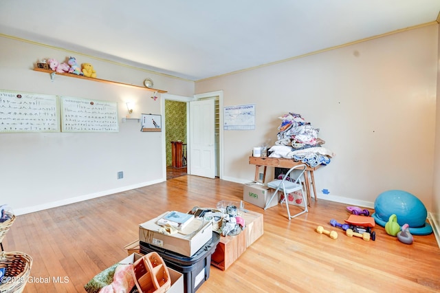 recreation room featuring baseboards and wood finished floors