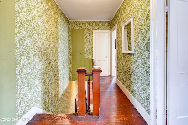 hallway with baseboards, wood finished floors, and wallpapered walls