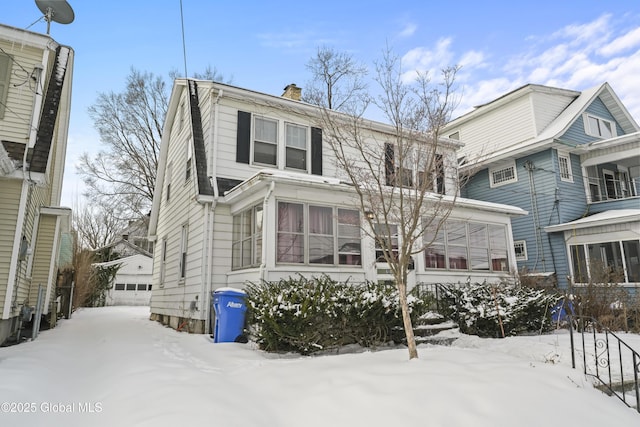 dutch colonial featuring a garage, a sunroom, and a chimney