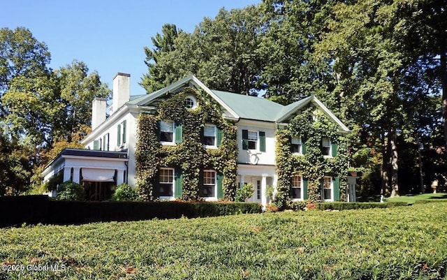 view of front of house featuring a front yard and a chimney