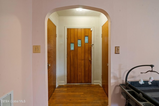 interior space with dark wood-type flooring and ornamental molding