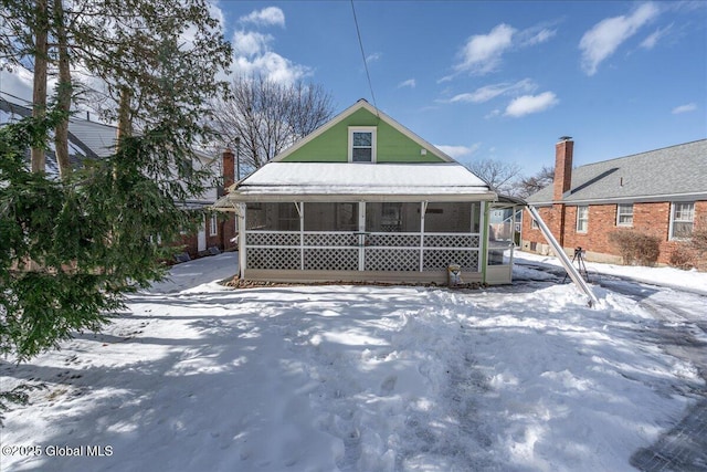 snow covered property featuring a sunroom