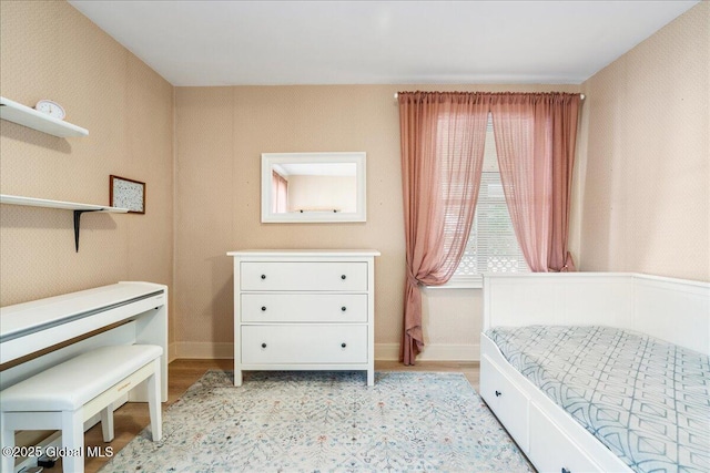 bedroom featuring light wood-style flooring and wallpapered walls