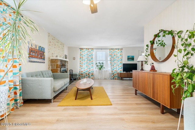 living area featuring light wood-type flooring and ceiling fan