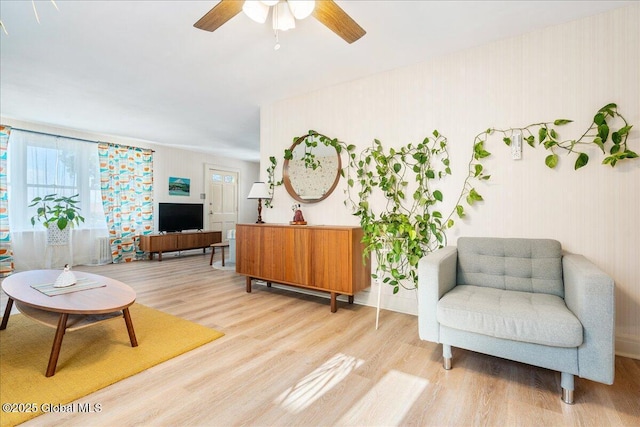 living area featuring light wood-style floors and ceiling fan