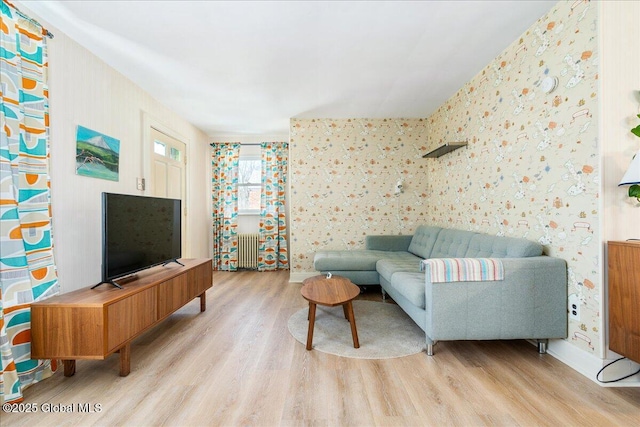 living room featuring light wood finished floors, radiator heating unit, and wallpapered walls