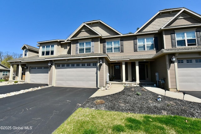 view of front facade with an attached garage, aphalt driveway, and a porch